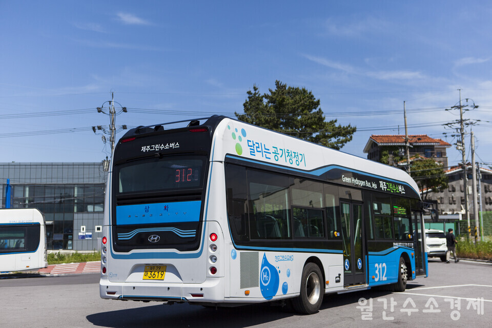 312번 수소버스가 함덕 회차지를 빠져 나가고 있다. 뒤쪽에 '달리는 공기청정기'라는 문구가 보인다.