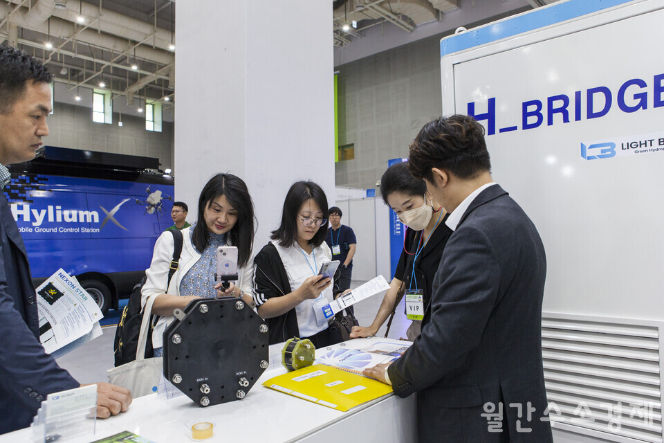 라이트브릿지 김종훈 대표(맨 오른쪽)가 수원컨벤션센터에서 열린 H2WORLD 2023 전시회에서 중국 참관단에 알칼라인 수전해 장치에 대해 설명하고 있다. 