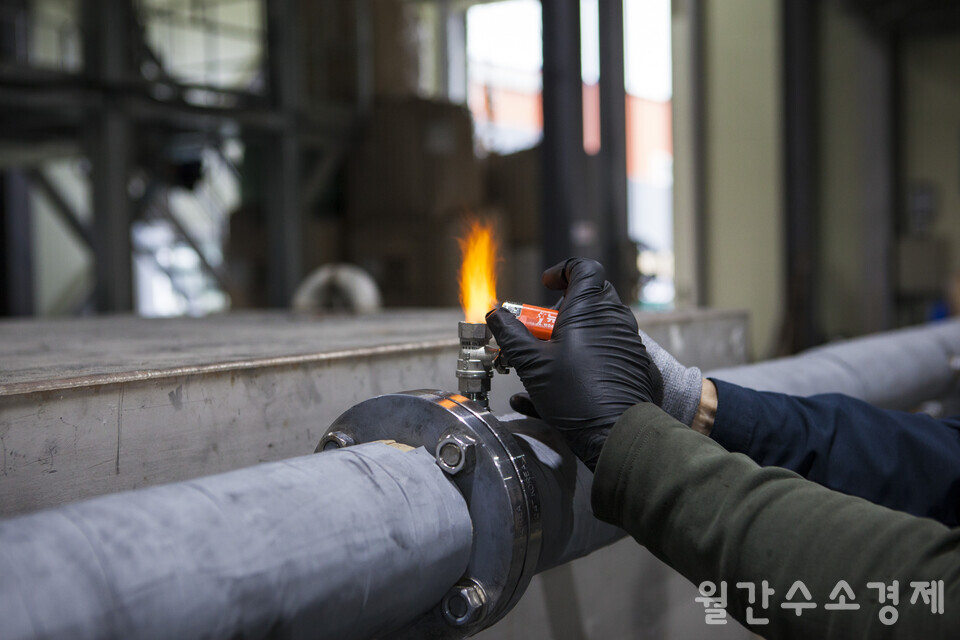 폐플라스틱으로 생산한 합성가스에 라이터를 대자 불이 붙는다.