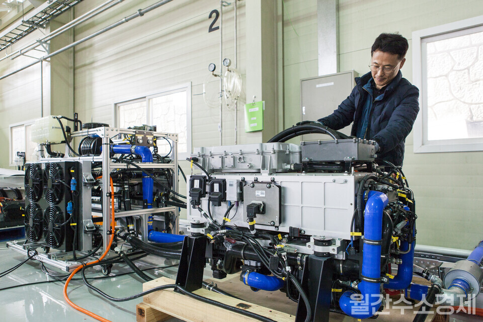 김정 책임연구원이 RT 크레인에 적용하기 위한 70kW급 수소연료전지 파워팩을 살펴보고 있다.(사진=성재경 기자)